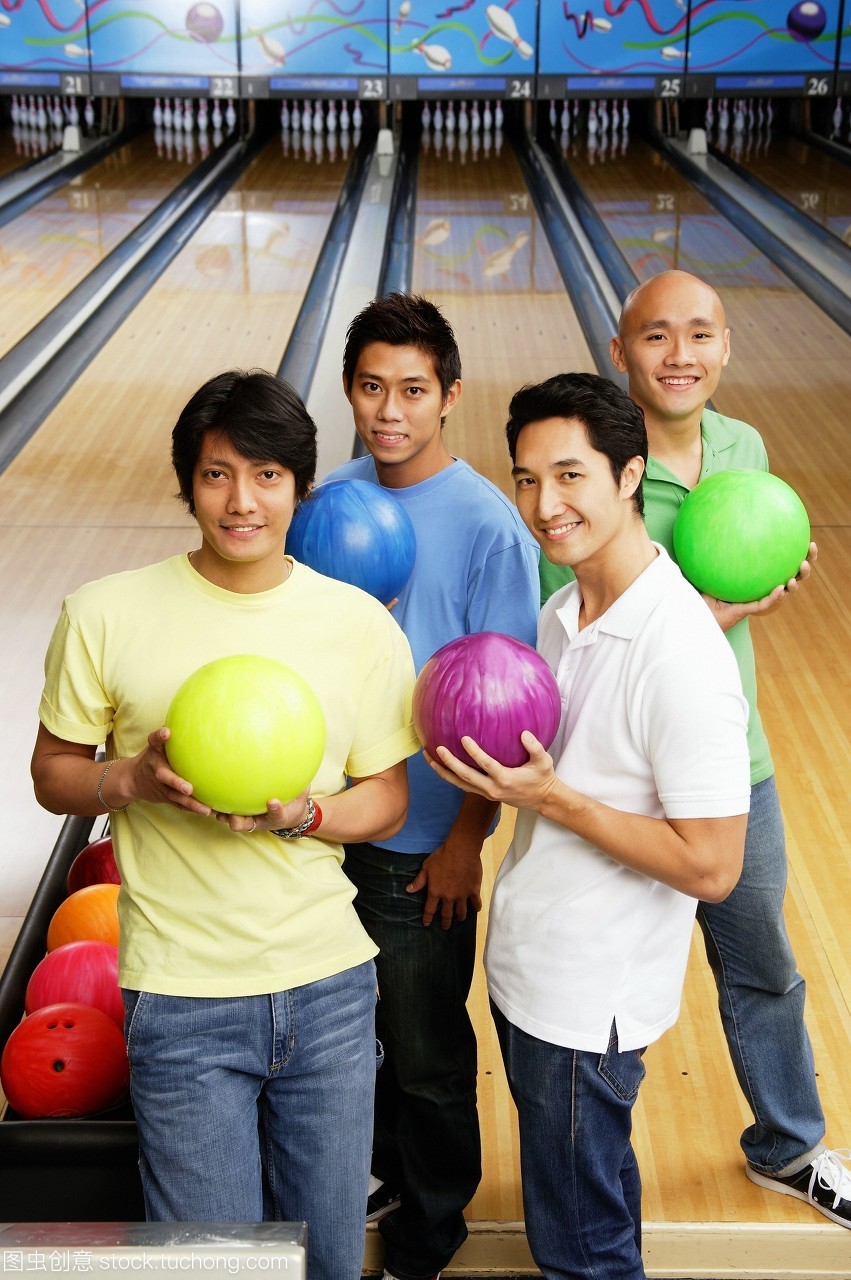 四個(gè)人站在保齡球館保齡球球